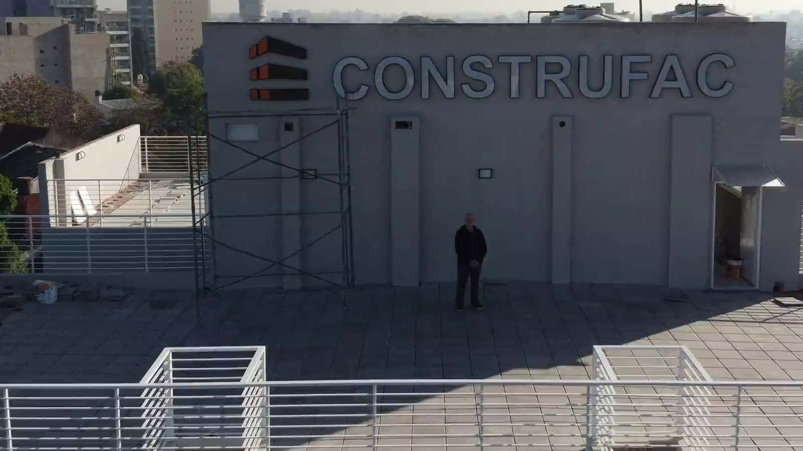 Vista aérea de la terraza de un edificio terminado por Construfac, con el cartel de la empresa